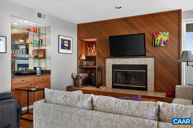 a living room with furniture a flat screen tv and a fireplace