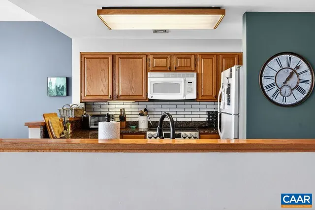 a kitchen with a sink a stove and a clock