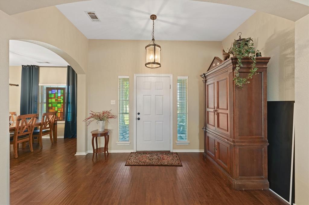 112 Springfield Lane Red Oak, TX 75165 - Photo 4 of 40 Entryway featuring high ceilings, wood-finish flooring, and an arched opening leading to the formal dining room