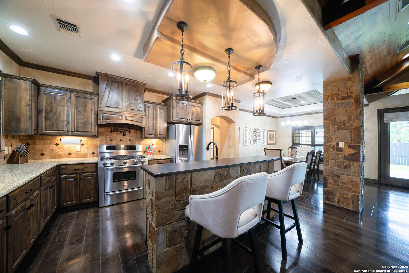 303 Schneider Street Poth, TX 78147 - Photo 13 of 41 a kitchen with stainless steel appliances kitchen island granite countertop a table chairs sink and cabinets