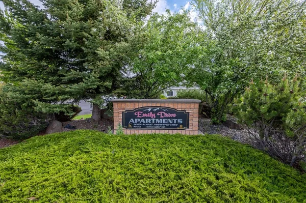 a sign that is sitting in the grass next to a road