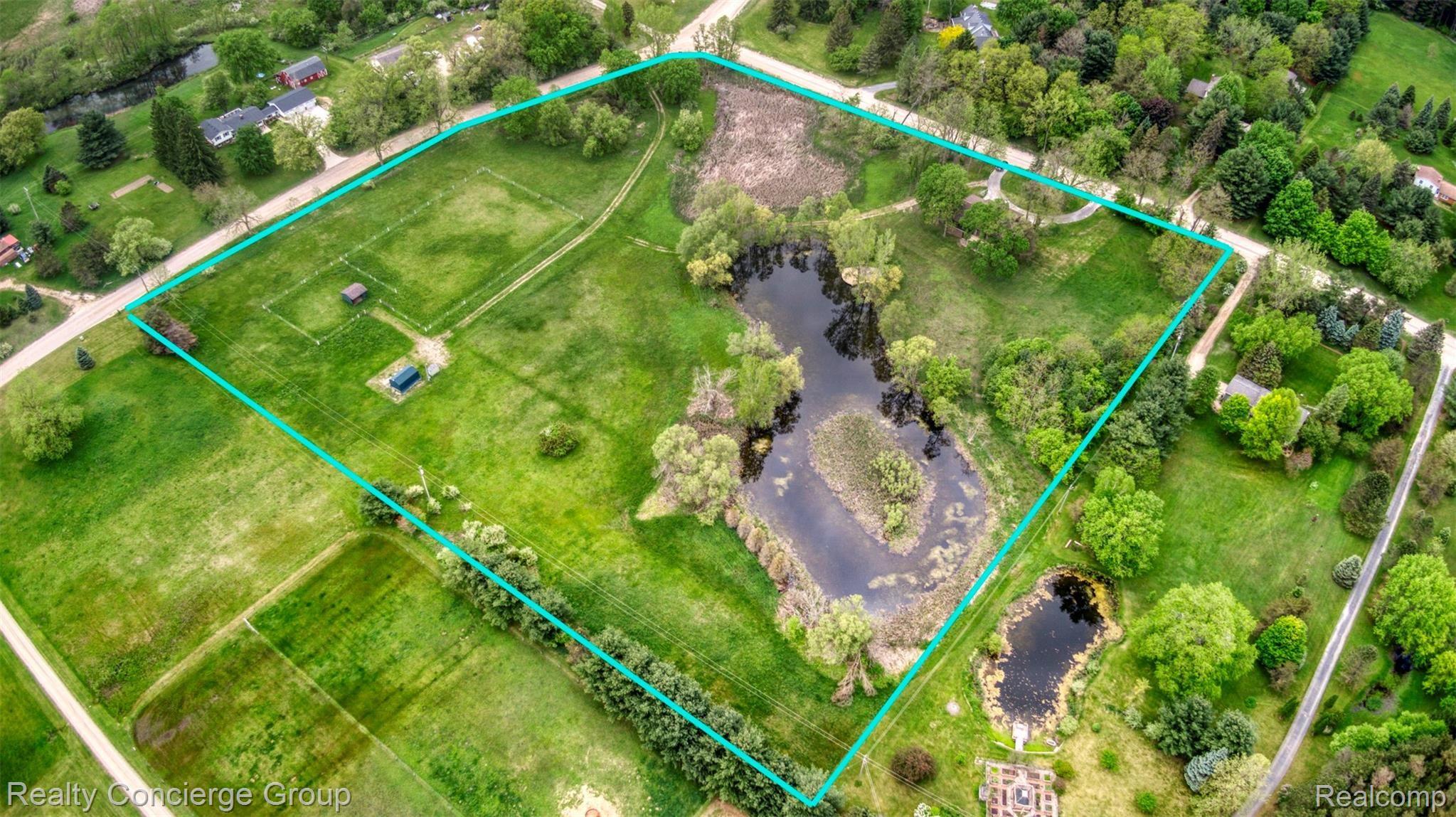 2110 East Clyde Road Howell, MI 48855 - Photo 41 of 44 Drone views of the 11 acre property; including private pond, connecting driveway to pastures, sheds and electric fencing