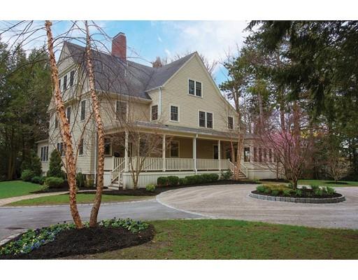 a view of a white house next to a yard with big trees