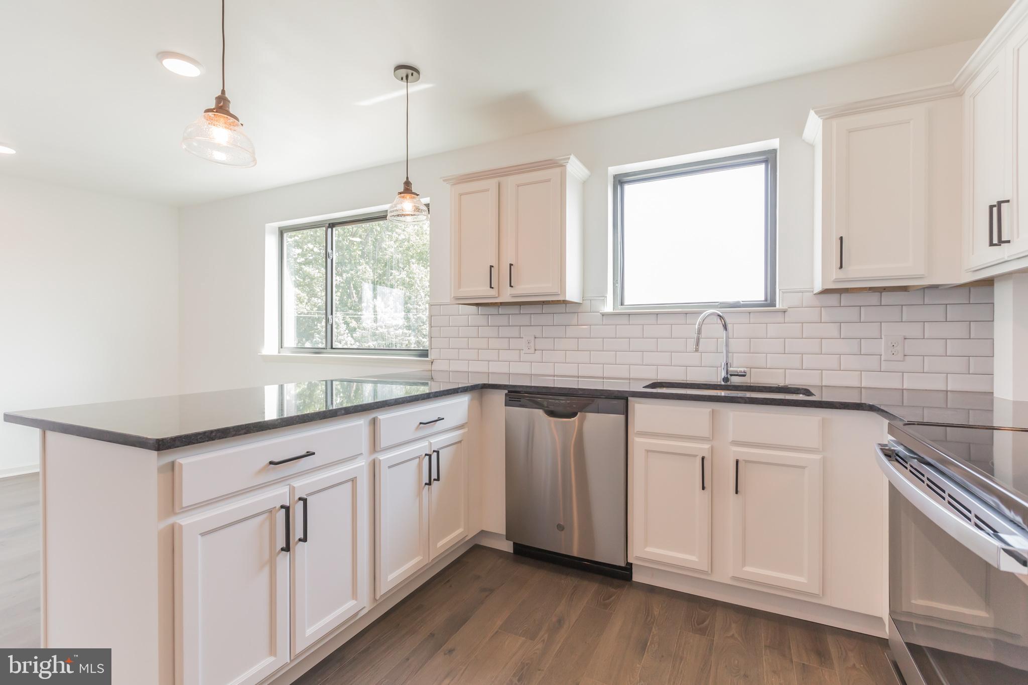 6778 Ridge Avenue, Unit 403 Philadelphia, PA 19128 - Photo 3 of 11 a kitchen that has a sink a window and cabinets