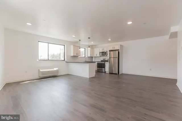 a view of a kitchen with wooden floor and electronic appliances