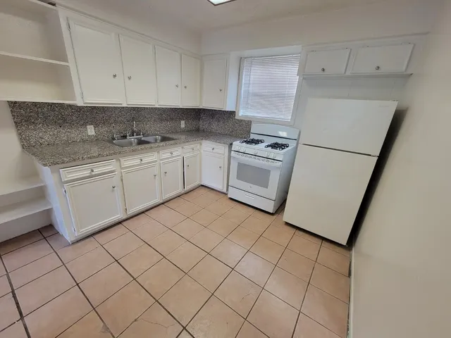 a kitchen with cabinets appliances and a sink