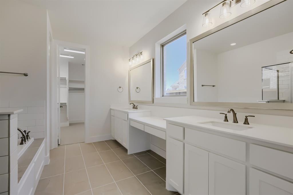 828 Stone Grv Road Lavon, TX 75166 - Photo 19 of 27 Bathroom featuring dual vanities with white cabinetry and countertops, framed mirrors, and bronze-finish fixtures