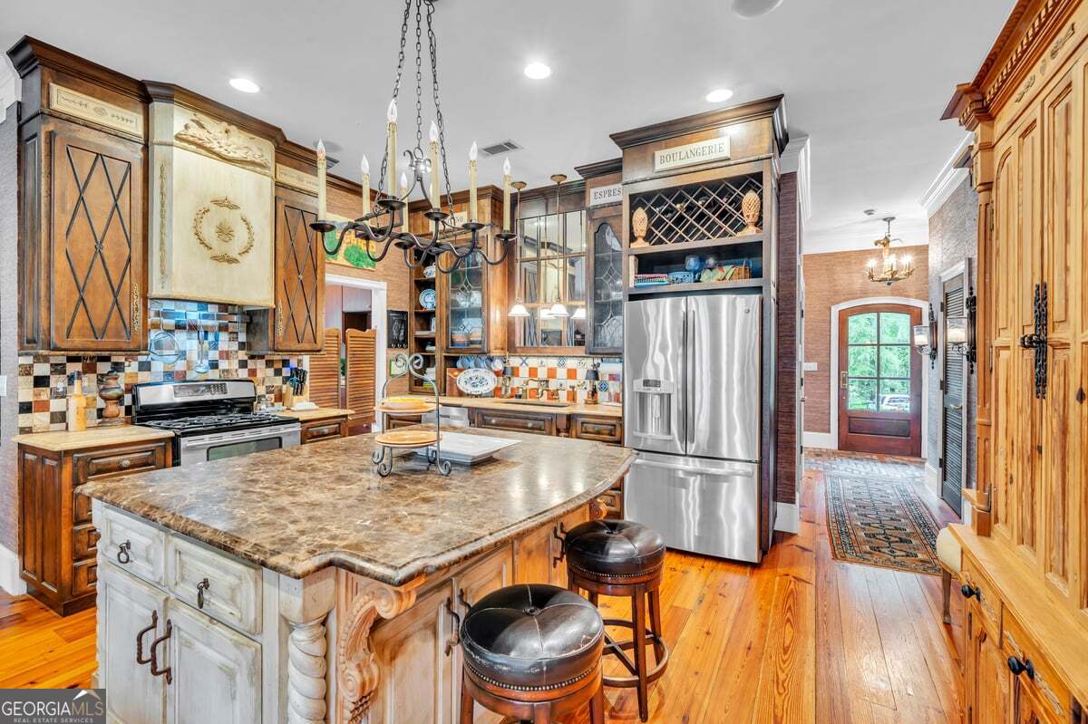 696 Cork Ferry Road Cordele, GA 31015 - Photo 17 of 79 a kitchen with stainless steel appliances granite countertop a table chairs and a refrigerator