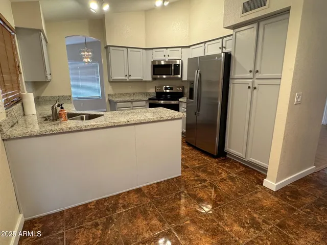 a kitchen with stainless steel appliances granite countertop a refrigerator and a sink