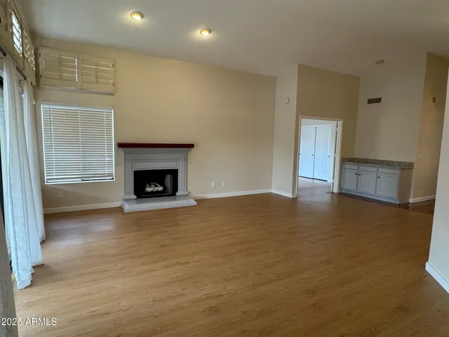 a view of empty room with wooden floor and fireplace