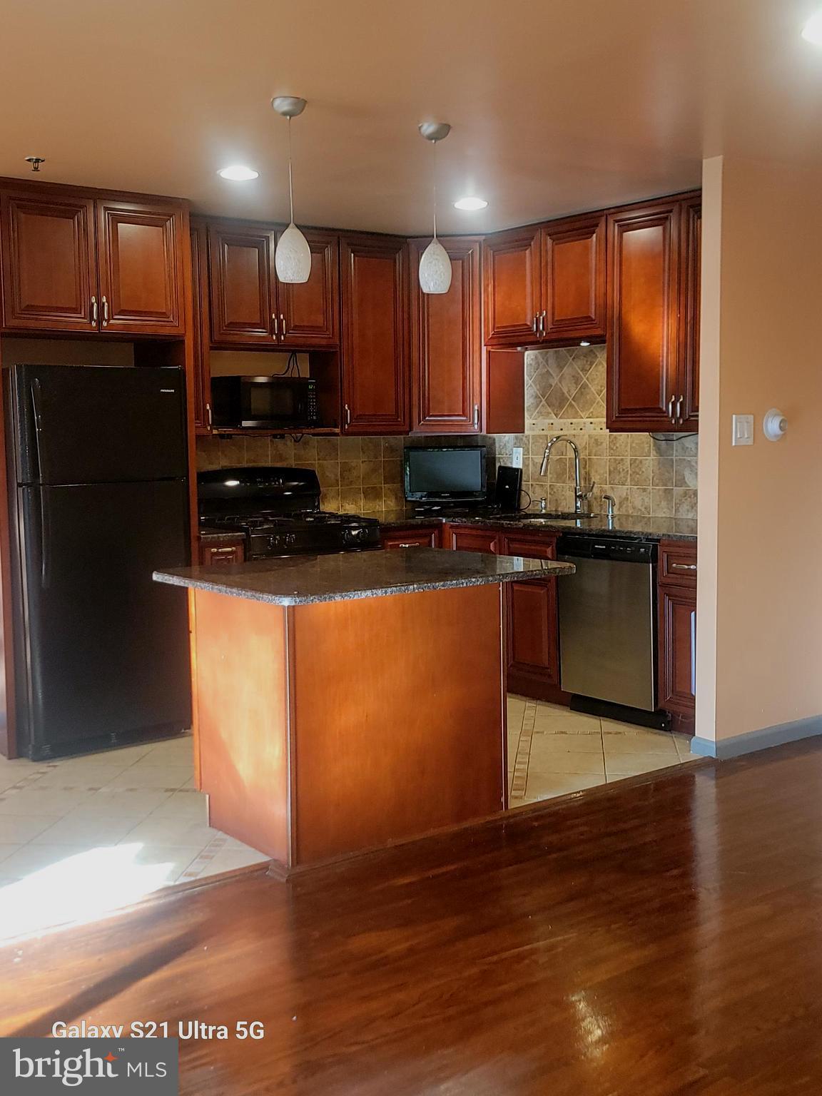 1600 Church Road, Unit C311 Wyncote, PA 19095 - Photo 9 of 26 a kitchen with stainless steel appliances granite countertop a refrigerator a stove a sink and a microwave