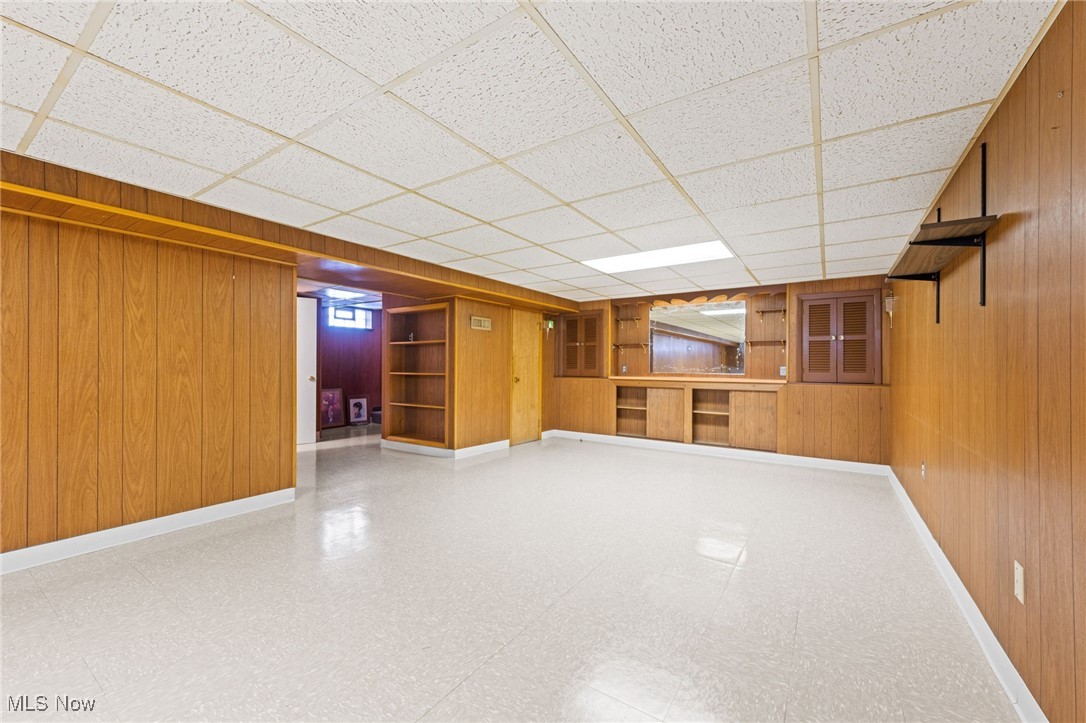 586 Bishop Road Cleveland, OH 44143 - Photo 17 of 24 Below grade area featuring wooden walls, baseboards, a drop ceiling, and tile patterned floors