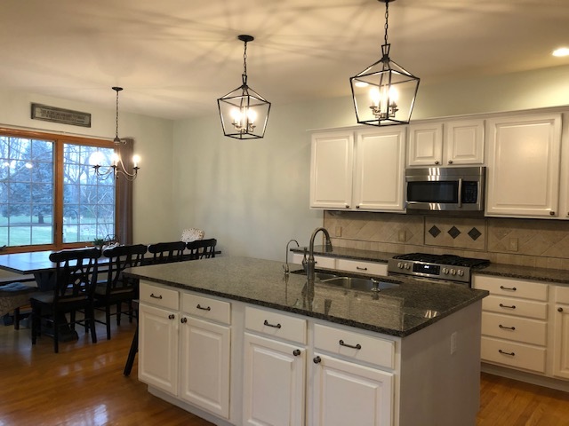 8708 South Rood Road Kingston, IL 60145 - Photo 3 of 15 a kitchen with granite countertop cabinets a sink a window and appliances