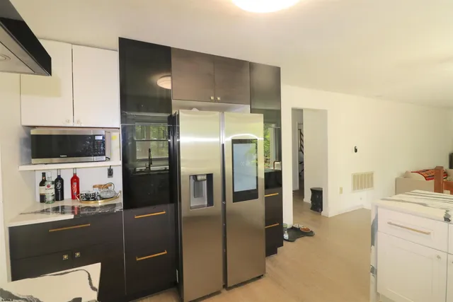 a kitchen with a refrigerator and a stove top oven