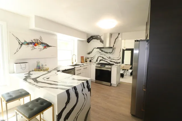 a view of a dining room with furniture and a kitchen