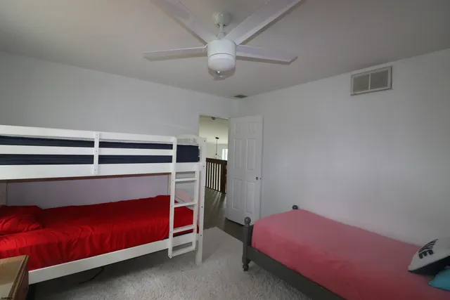 a bedroom with a bed and a ceiling fan