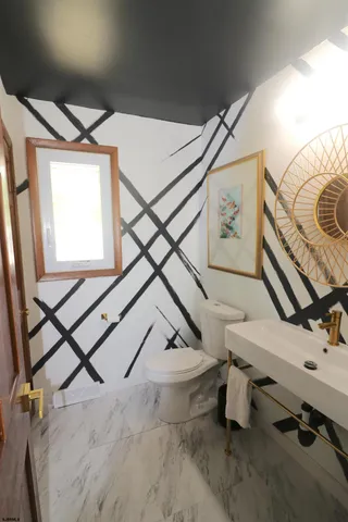 a bathroom with a sink mirror and toilet