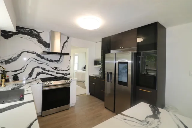 a kitchen with stainless steel appliances granite countertop a refrigerator and a stove top oven