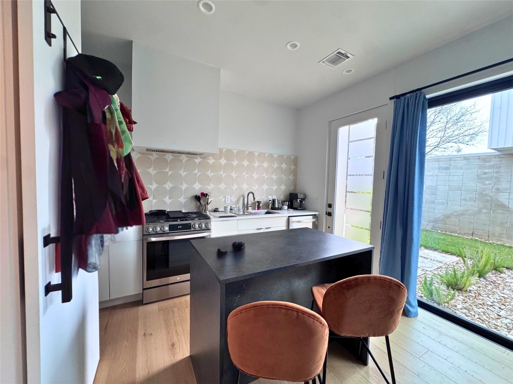 1206 Luna Street, Unit 2 Austin, TX 78721 - Photo 11 of 20 a view of a kitchen area with furniture and wooden floor