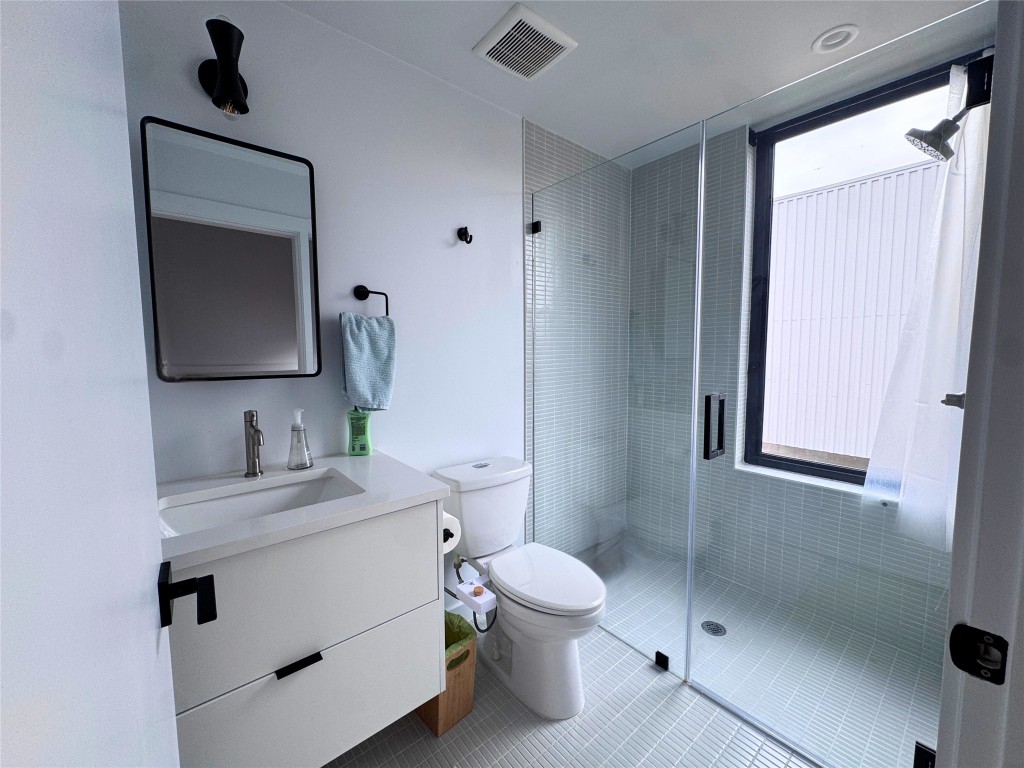 1206 Luna Street, Unit 2 Austin, TX 78721 - Photo 17 of 20 a bathroom with a toilet sink and mirror