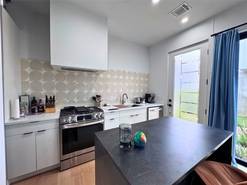 1206 Luna Street, Unit 2 Austin, TX 78721 - Photo 9 of 20 a kitchen with stainless steel appliances a stove a sink a counter space and cabinets