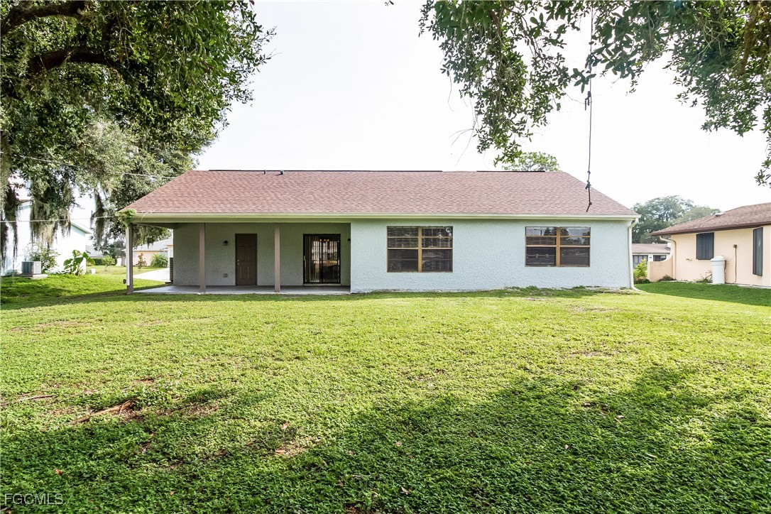 2802 31st Street Southwest Lehigh Acres, FL 33976 - Photo 15 of 16 a front view of a house with a garden