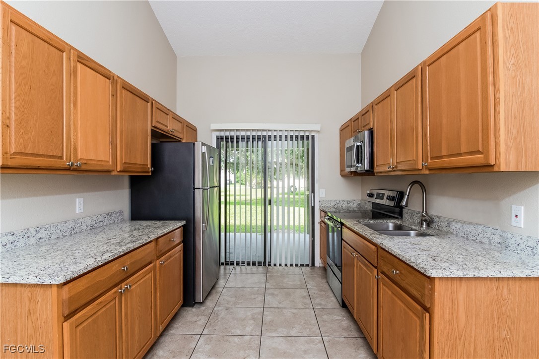 2802 31st Street Southwest Lehigh Acres, FL 33976 - Photo 6 of 16 a kitchen with stainless steel appliances granite countertop a stove sink and cabinets