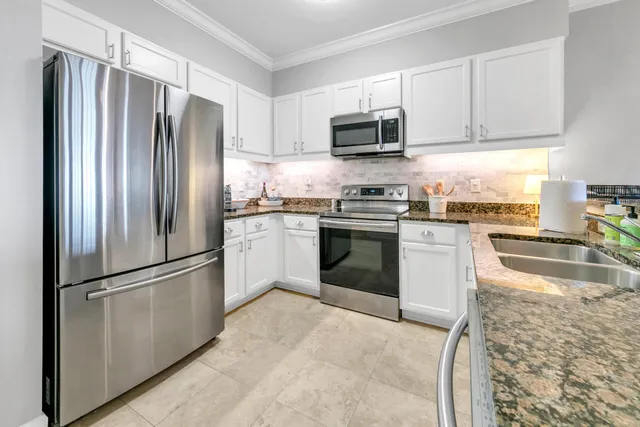 a kitchen with stainless steel appliances granite countertop a refrigerator stove a sink and microwave