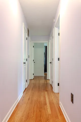 a view of a hallway with wooden floor