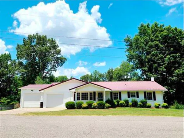 a house with green field in front of it