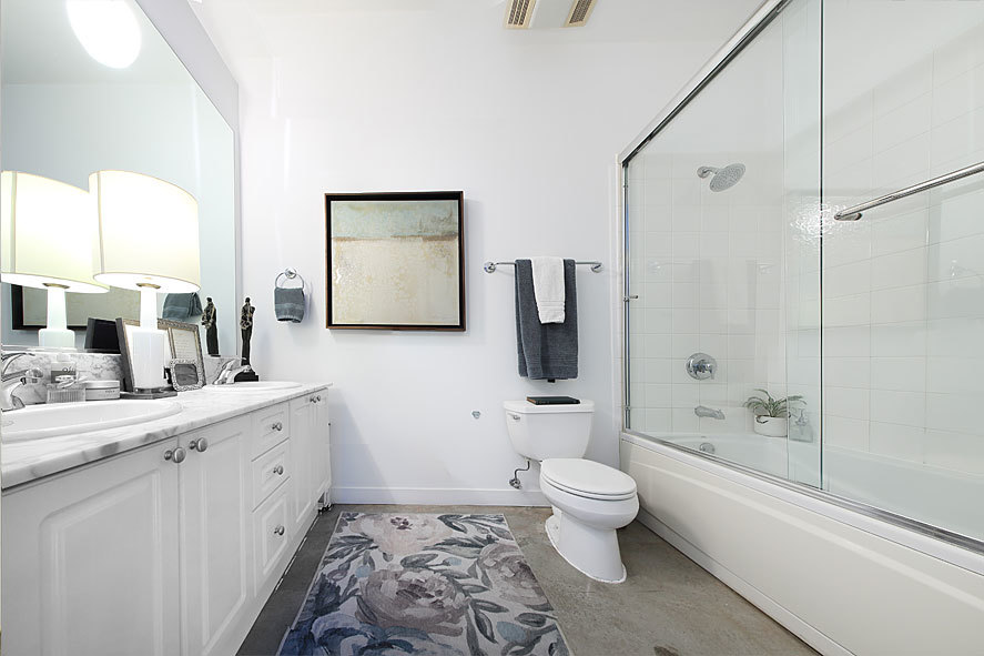 939 West Madison Street, Unit 510 Chicago, IL 60607 - Photo 11 of 13 a bathroom with a double vanity sink toilet mirror and shower
