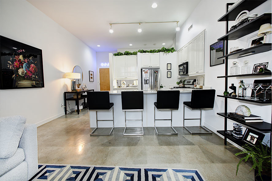 939 West Madison Street, Unit 510 Chicago, IL 60607 - Photo 5 of 13 a kitchen with stainless steel appliances kitchen island granite countertop a dining table chairs and a refrigerator