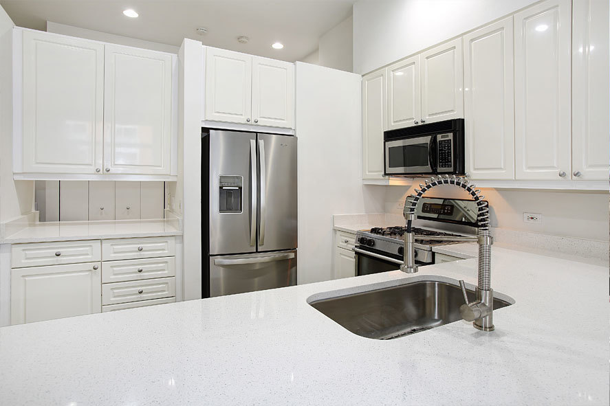 939 West Madison Street, Unit 510 Chicago, IL 60607 - Photo 8 of 13 a kitchen with granite countertop a refrigerator stove and microwave