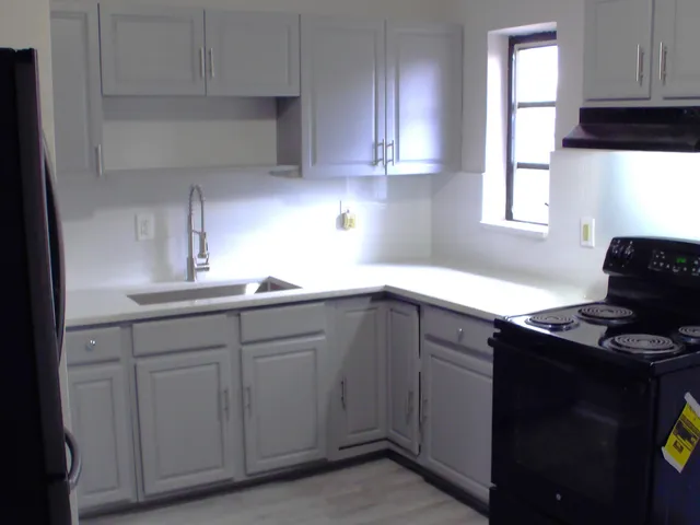 a kitchen with cabinets appliances and a window