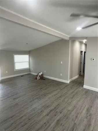 an empty room with wooden floor and window