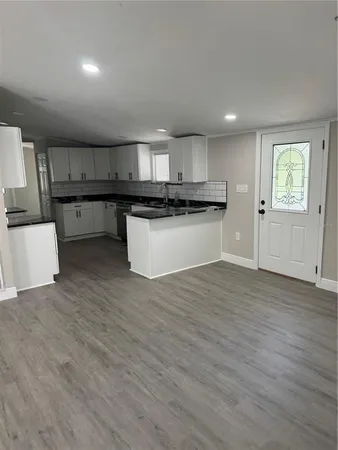 a kitchen with kitchen island granite countertop wooden cabinets and a sink