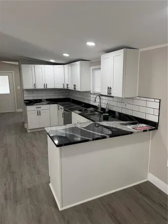 a kitchen with granite countertop a sink and a stove top oven