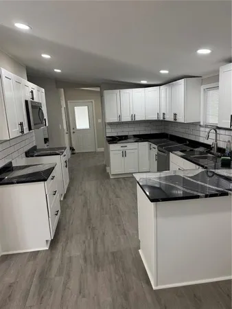 a kitchen with stainless steel appliances granite countertop a stove a sink and a refrigerator