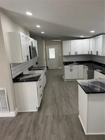 a kitchen with stainless steel appliances granite countertop a sink stove and cabinets