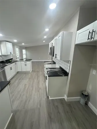 a kitchen with stainless steel appliances a refrigerator and wooden floor