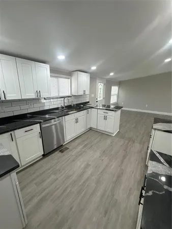 a large kitchen with lots of counter space and wooden floor