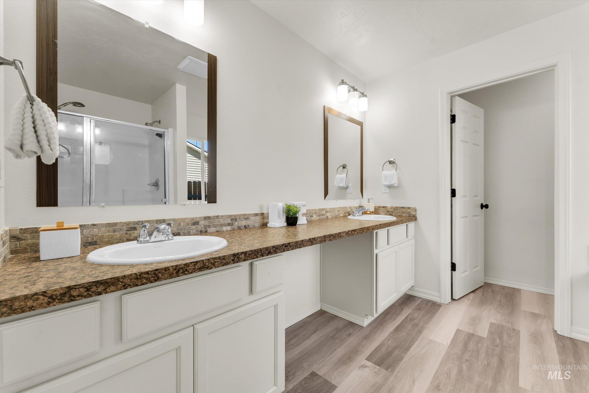5602 Barkley Way Caldwell, ID 83607 - Photo 15 of 36 Full bathroom with double vanity, a shower stall, and light wood finished floors