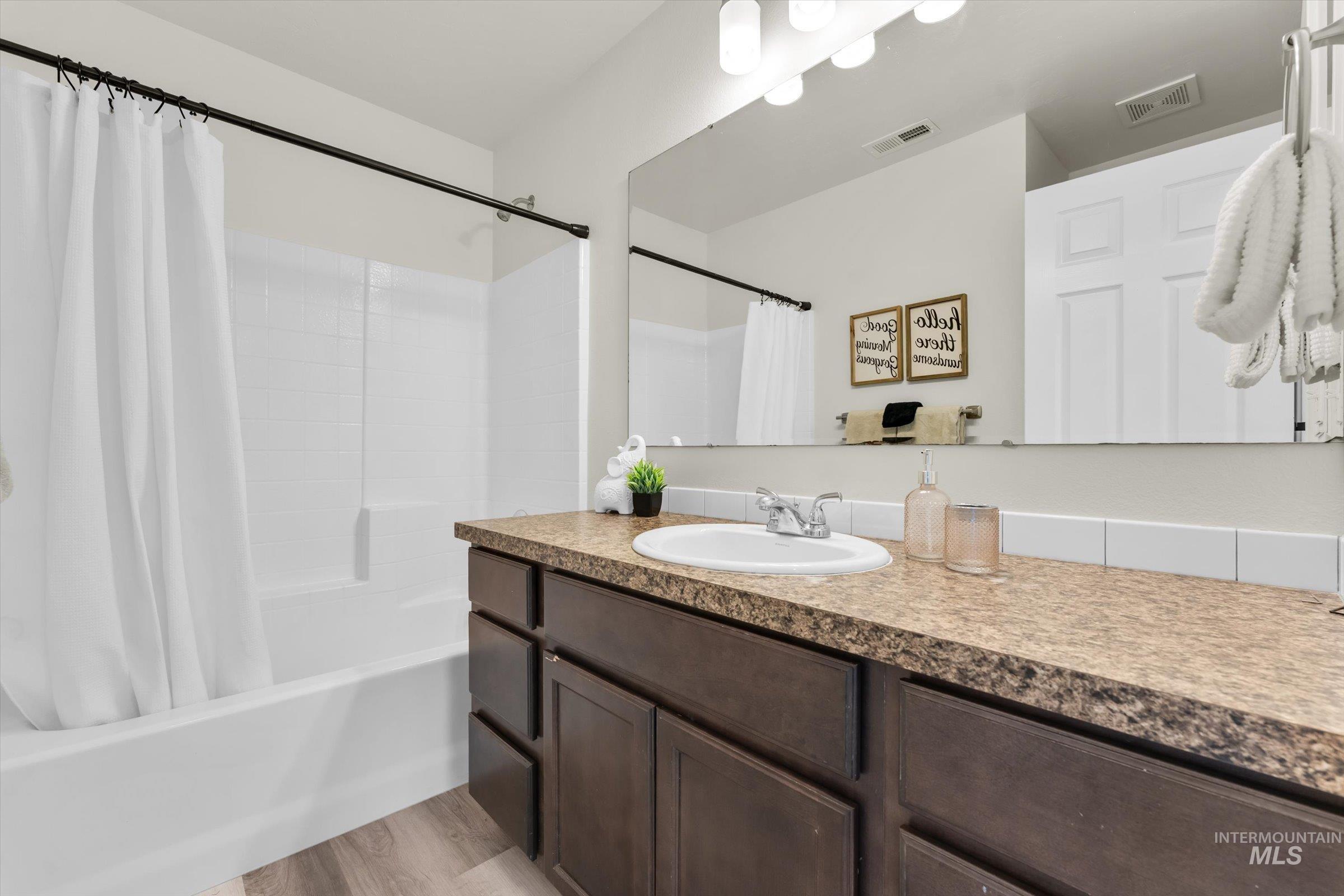 5602 Barkley Way Caldwell, ID 83607 - Photo 26 of 36 Full bath with vanity, shower / bath combination with curtain, and light wood-style flooring