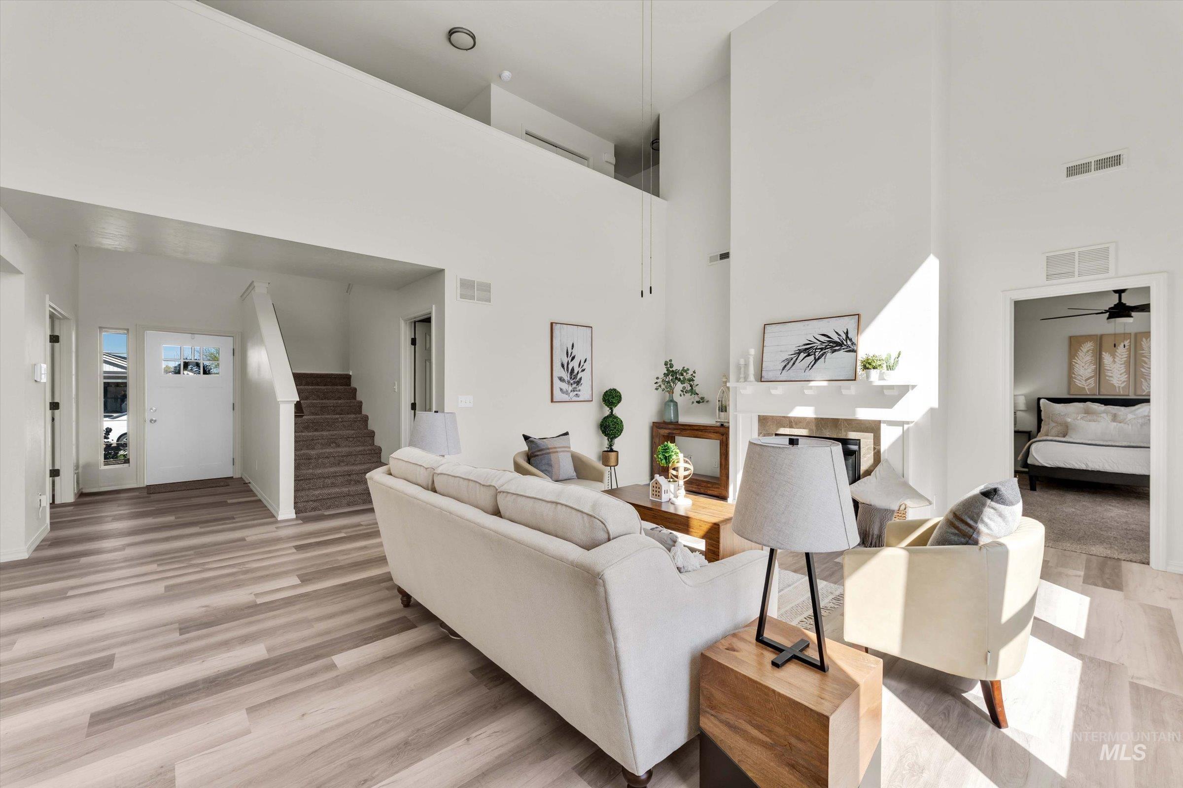5602 Barkley Way Caldwell, ID 83607 - Photo 4 of 36 Living room with light wood-type flooring, a high ceiling, and a ceiling fan