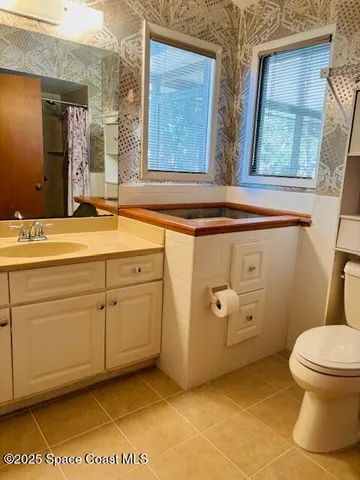 a bathroom with a granite countertop sink mirror vanity and a toilet