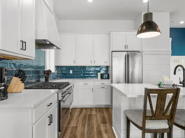 a kitchen with granite countertop white cabinets and stainless steel appliances