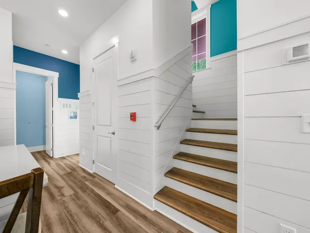 a bed sitting in a spacious bedroom next to a window and a flat screen tv