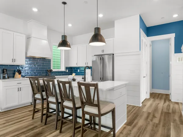 a kitchen with a table chairs refrigerator and microwave