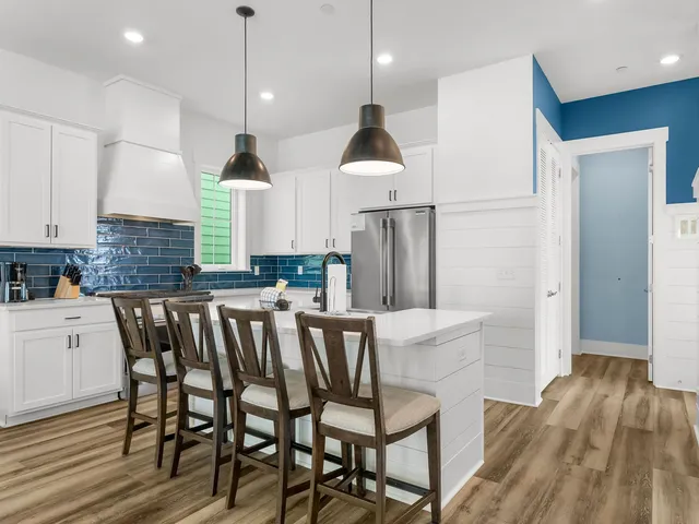 a kitchen with a table chairs refrigerator and microwave