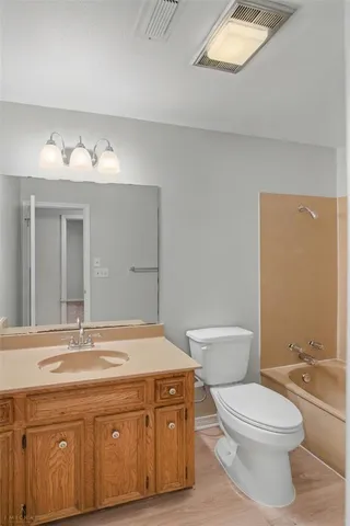 a bathroom with a granite countertop toilet a sink and a mirror